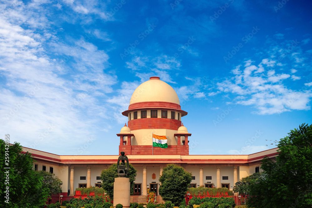 Supreme Court of India building in New Delhi with Indian flag under blue sky