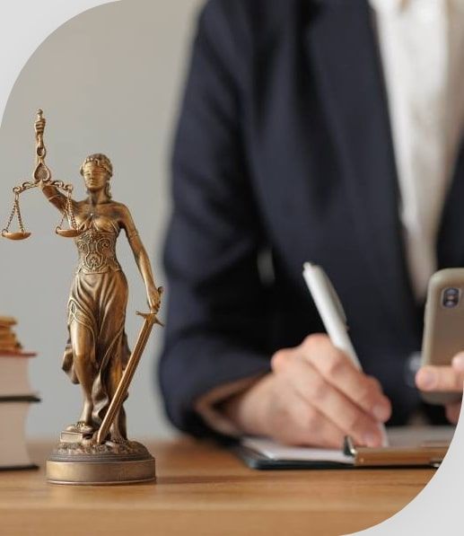 Trusted immigration agency professional reviewing documents beside the Lady Justice statue, symbolizing ethical and expert immigration guidance.