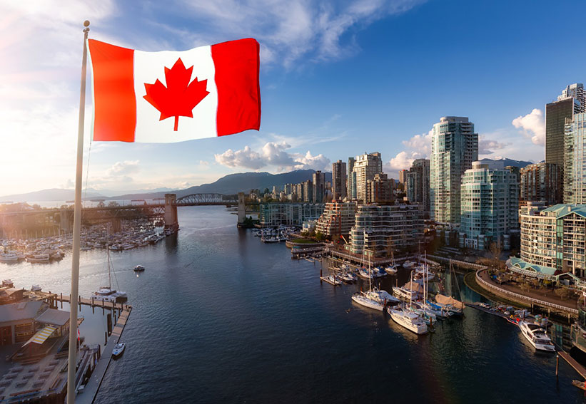 Canadian flag overlooking a modern city skyline and waterfront, representing Canada immigration updates and study opportunities for international students in 2026.